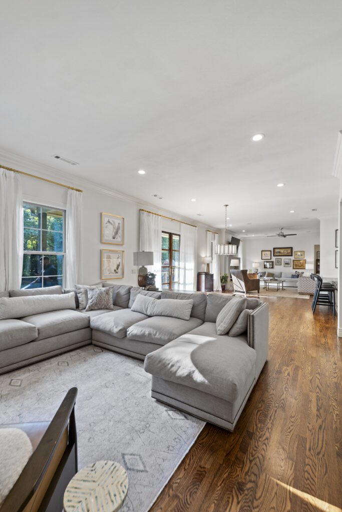 Remodeled living room with a sectional sofa opening to the kitchen by J&E Home Remodeling