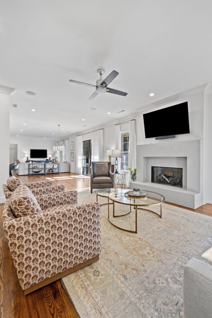 Open-concept living room with a fireplace and vaulted ceiling remodeled in Northwest Arkansas